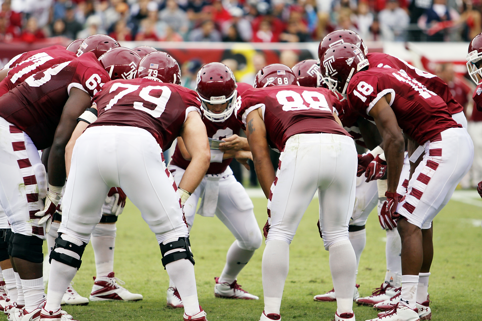 Football team huddling together.